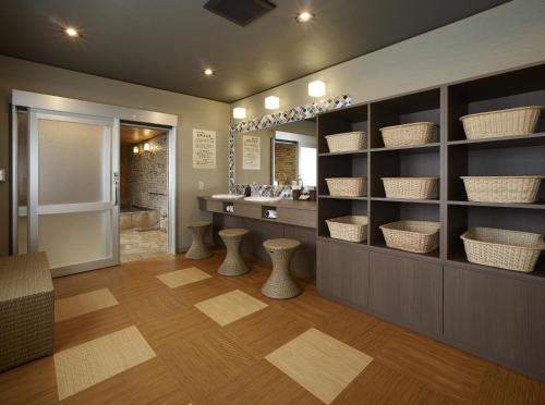 a bathroom with a sink and a vanity with baskets at Wakamatsu Honten in Narita