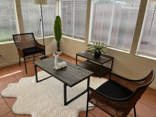 a living room with a table and two chairs and a plant at Saikwan Valley Family Home in Milpitas