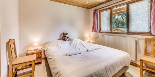 a teddy bear sitting on top of a bed in a bedroom at Chalet Les Lauzes - Chalets pour 10 Personnes MAE-3288 in Champagny-en-Vanoise