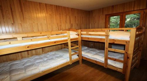 une chambre avec trois lits superposés dans une cabine dans l'établissement Résidence Le Roselin - 4 Pièces pour 8 Personnes MAE-3296, à Champagny-en-Vanoise