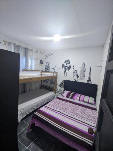 sypialnia z 2 łóżkami i ścianą z rysunkami w obiekcie Apartamento cerca al mar w mieście Tolú