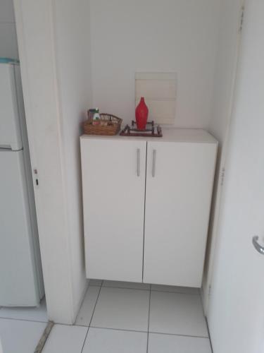 a kitchen with white cabinets in a white room at Eduardo Gimenes Palazzi in São Vicente