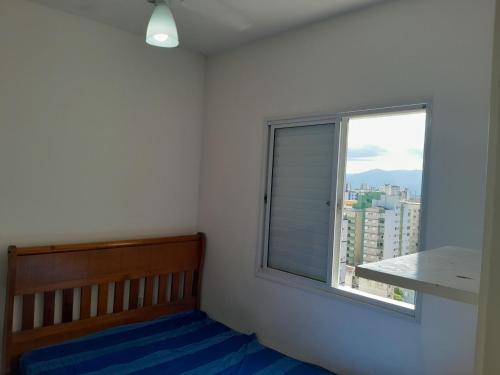 a room with a window with a bed and a table at Eduardo Gimenes Palazzi in São Vicente