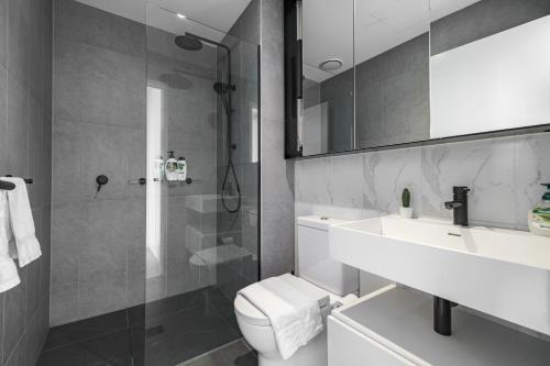 uma casa de banho com um WC, um lavatório e um chuveiro em Modern 2br Apartment With Free Carpark And Pool em Melbourne