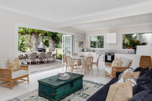 una sala de estar con un sofá y una mesa en The Patonga Cottage, en Patonga