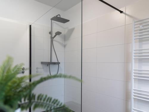 a shower in a bathroom with a glass door at Gästehaus Moorblick in Osten