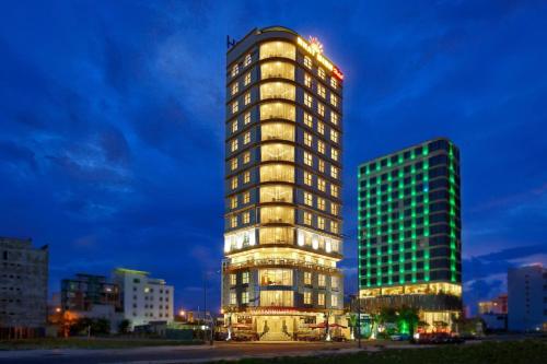 a tall building is lit up at night at Nhat Minh Hotel and Apartment in Da Nang
