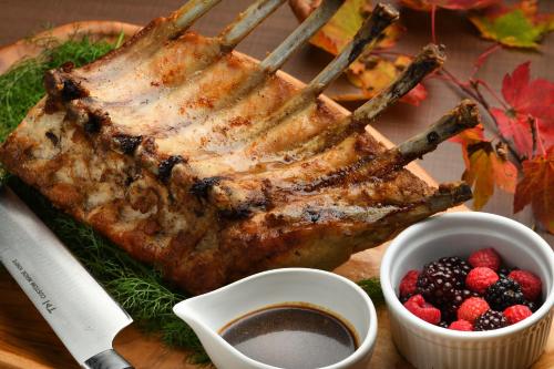 a piece of meat on a cutting board with berries at Hachimantai Mountain Hotel & Spa in Hachimantai