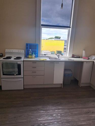 a kitchen with a sink and a window at SUSAN'S SWEET HOME Hamilton CBD in Hamilton