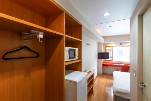 um pequeno quarto com uma cama e um micro-ondas em M Hotel Niseko em Niseko