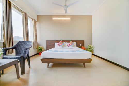 a bedroom with a bed and a table and chairs at Hotel O Peaceful Stay Keshav Nagar. in Kharadi