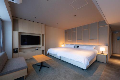 a bedroom with a large bed and a tv at OND HOTEL（オンドホテル） in Takeo