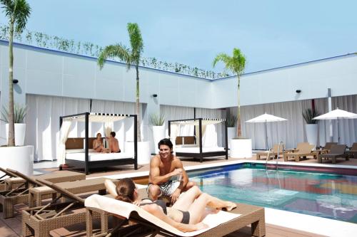 two women sitting in the pool at a hotel at Riu Plaza Guadalajara in Guadalajara