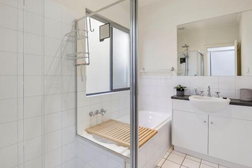 a white bathroom with a sink and a shower at 3 61 St Andrews Boulevard in Normanville