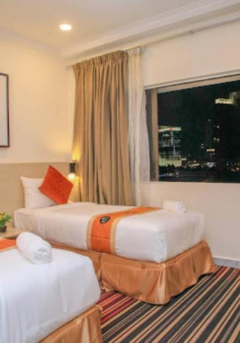 a hotel room with two beds and a window at hotel bintang in Kuala Lumpur