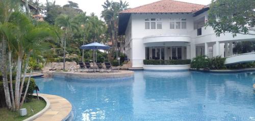 a swimming pool in front of a house at Sea View Villa @ Nongsa Resort in Telukmataikan