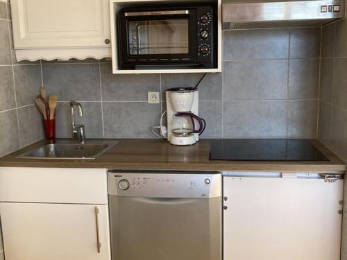 une cuisine avec un évier et un micro-ondes dans l'établissement Appartement 2 pièces, 6 pers, Alpe d'Huez, animaux bienvenus - FR-1-405-355, à Huez