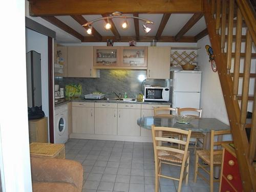 une cuisine avec une table et un réfrigérateur dans l'établissement Villa 3 Pièces Climatisée, 5 Pers., à 800m de la Plage avec Jardin et Parking Sécurisé - FR-1-776-77, à Argelès-sur-Mer
