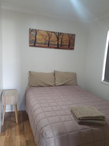 a bed in a bedroom with a picture on the wall at Highway Tourist Village in Narrabri