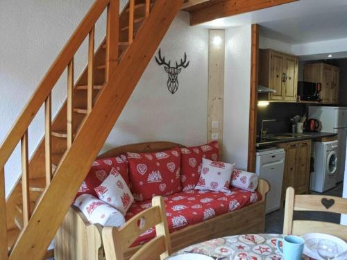 - un salon avec un canapé rouge sous un escalier dans l'établissement Charmant studio cabine avec mezzanine au centre de Morzine, idéal pour 6 personnes - FR-1-524-125, à Morzine