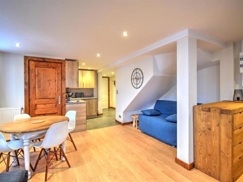 un salon avec une table et un canapé bleu dans l'établissement Chalet spacieux à Morzine avec poêle à bois et Wi-Fi - FR-1-524-126, à Morzine