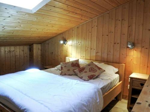 une chambre avec un lit dans un mur en bois dans l'établissement Morzine : Studio 6 pers, mezzanine, terrasse, parking, centre, WIFI - FR-1-524-127, à Morzine