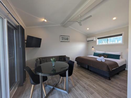 a bedroom with a bed and a table and a couch at Ballina Beach Nature Resort in Ballina