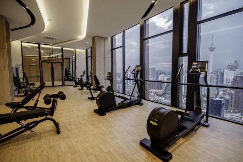 een fitnessruimte met loopbanden en crosstrainers in een gebouw bij Sleeping Lion Suites in Kuala Lumpur