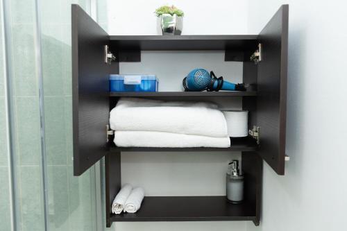 a shelf in a bathroom with towels on it at Casa Postal, Loft cerca del Centro, wifi rápido y estacionamiento in Oaxaca City