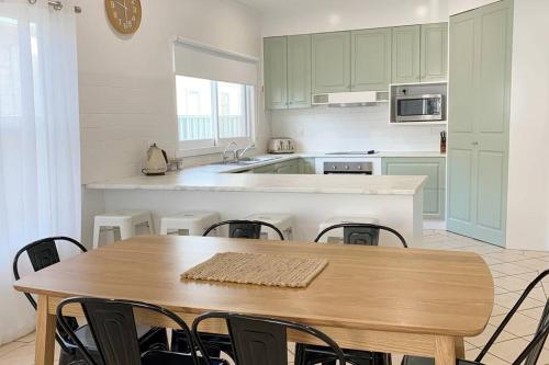 a kitchen with a wooden table with chairs and a sink at Family home central to everything in Mildura