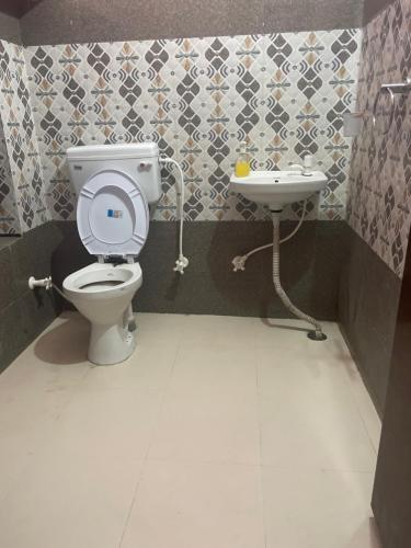 uma casa de banho com um WC e um lavatório em Star inn hotel em Meerut