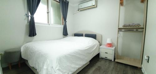 a bedroom with a white bed and a window at Comfy & Cozy in Seoul