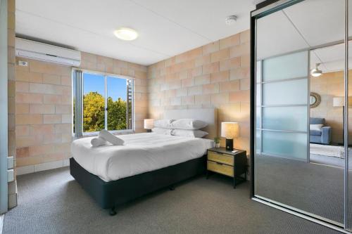 a bedroom with a large bed and a large window at Sleek Apartment with Pool and Rooftop Terrace in Gold Coast