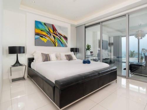 a bedroom with a large bed with a painting on the wall at 2-Bedroom Apartment , Kata Beach, Stunning Seaview (I6) in Kata Beach