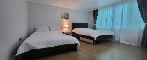 a hotel room with two beds and a window at Comfy & Cozy in Seoul