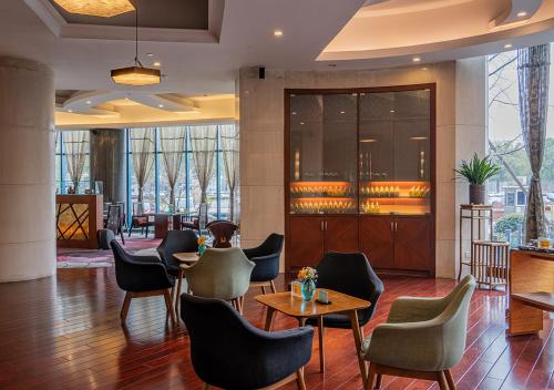 eine Lobby mit Stühlen und Tischen in einem Gebäude in der Unterkunft BEST WESTERN PREMIER Ocean Hotel in Yiwu