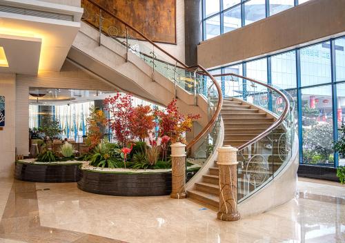 eine Lobby mit einer Wendeltreppe in einem Gebäude in der Unterkunft BEST WESTERN PREMIER Ocean Hotel in Yiwu