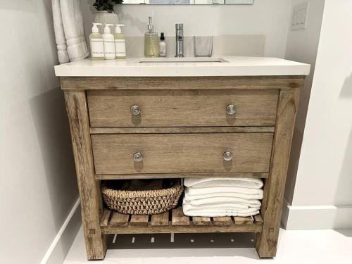 a wooden bathroom vanity with a sink and a counter at New and Cozy Cottage Minutes to Blue Mountain in Meaford
