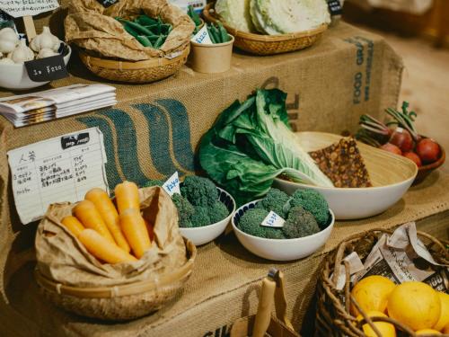 a display of vegetables in baskets on a table at まちごとホテルLOOP 小林 in Makata