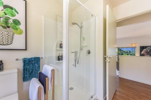 a bathroom with a shower with a glass door at Vista Del Porto - Havelock Holiday Home in Havelock