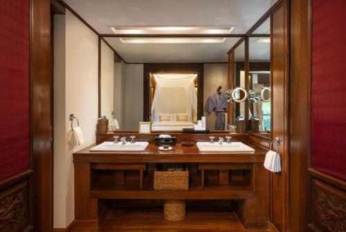 łazienka z 2 umywalkami i dużym lustrem w obiekcie Governor's Residence w mieście Rangun