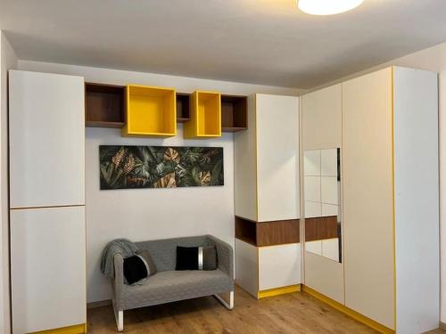 een woonkamer met een stoel en een aantal kasten bij Modern fully equipped studio -central- Carol Park in Boekarest