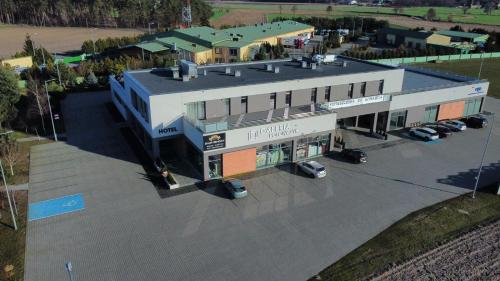 an overhead view of a building with cars parked in a parking lot at Restauracja & Pokoje Gościnne Polowczyk in Miąskowo