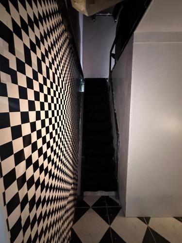 a stairway with a checkered floor and a black and white tile wall at Kika in Limpio