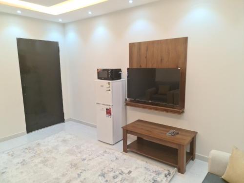 a living room with a tv and a coffee table at فخامة اليمامة للشقق الفندقية in Riyadh