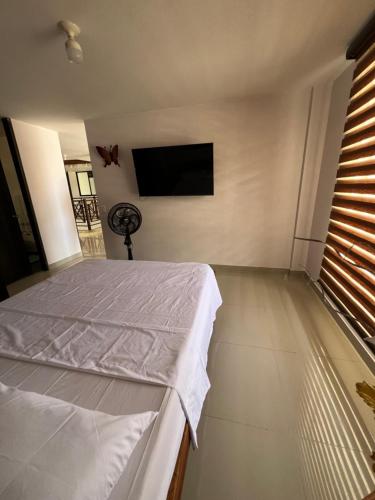 a bedroom with a bed and a flat screen tv at Acogedor apartamento en San Gil. in San Gil