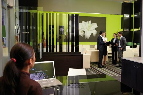 a group of people standing in a room with a laptop at Riu Plaza Guadalajara in Guadalajara