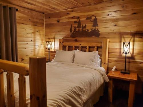 een slaapkamer met een bed in een blokhut bij Luxury Cabin w/ Game Room & Hot Tub at Cave Run Lake in Wellington