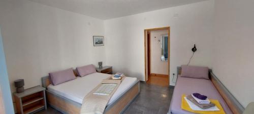 a small bedroom with two beds and a table at Rooms Katja - 10 m from beach in Gradac
