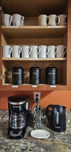 a counter with a coffee maker and cups on a shelf at GameRoom, HotTub, Piano, 5mi to OldManCave - Hocking Hills Copper House in Laurelville